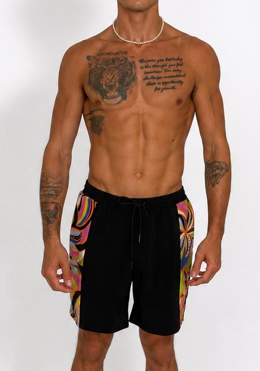 Man wearing black shorts with colorful patterns on a white background